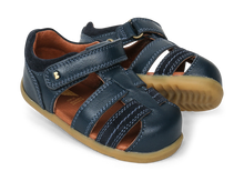 Calzado Step Up Roam de BOBUX en azul marino para los primeros pasos del bebé, con diseño cómodo y flexible.