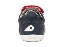Calzado Step Up para bebés de BOBUX en azul marino, rojo y plateado metalizado, ideal para primeros pasos en cancha de césped.