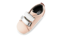 Calzado para bebé Step Up Seashell de BOBUX en plata metálico y blanco para primeros pasos en césped.