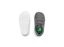 Calzado para bebés Step Up de BOBUX en color gris y verde para jugar en cancha de césped, ideal para primeros pasos.