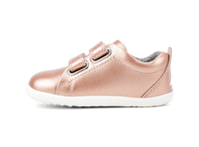 Calzado Step Up de BOBUX en oro rosa para bebés, ideal para los primeros pasos en pista de hierba, con diseño cómodo y seguro.