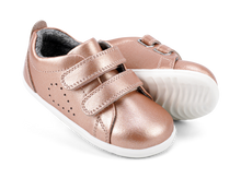 Zapatos Step Up BOBUX para bebés en color oro rosa, ideales para los primeros pasos en cancha de césped.