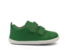 Zapatos Step Up BOBUX España y Portugal para bebés en césped esmeralda, ideales para sus primeros pasos.
